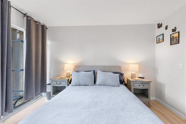 bedroom with baseboards and light wood-style flooring