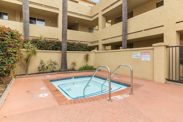 view of swimming pool with a hot tub