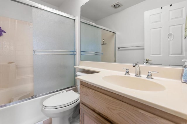 full bathroom featuring vanity, toilet, and shower / bath combination with glass door