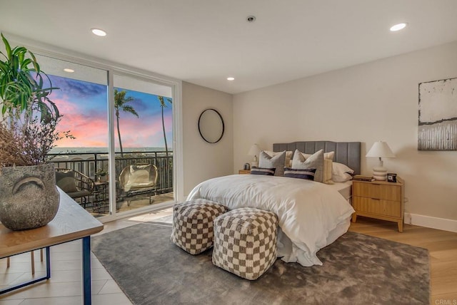 bedroom featuring access to exterior, baseboards, floor to ceiling windows, recessed lighting, and wood finished floors