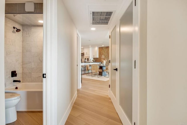 hallway with visible vents, recessed lighting, baseboards, and light wood-style floors