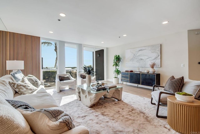 living area with floor to ceiling windows, recessed lighting, and wood finished floors