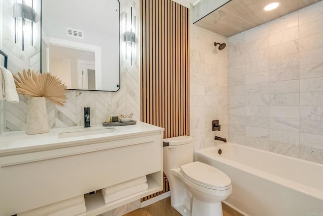 full bathroom featuring vanity, visible vents, bathing tub / shower combination, toilet, and tasteful backsplash