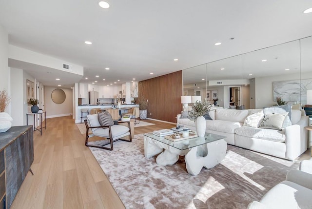 living room with recessed lighting, light wood-style floors, visible vents, and baseboards