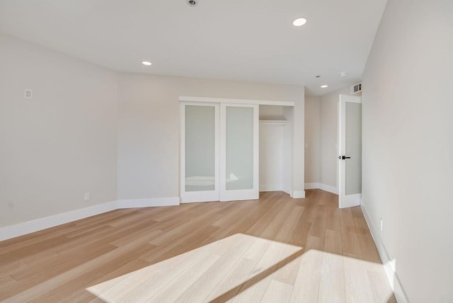 unfurnished bedroom featuring light wood-style flooring, recessed lighting, baseboards, and a closet