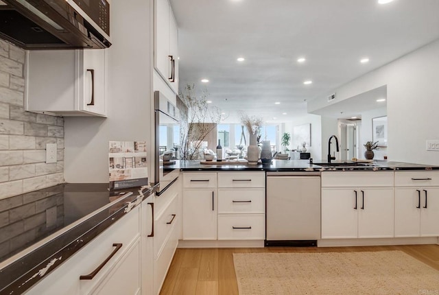 kitchen with dishwasher, light wood-style floors, dark countertops, ventilation hood, and recessed lighting