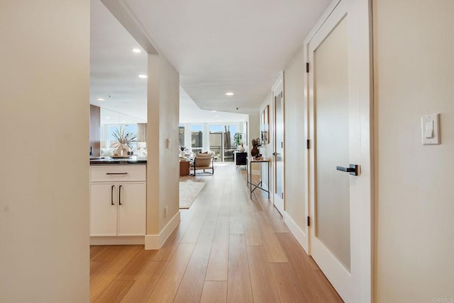 corridor featuring light wood-type flooring and recessed lighting