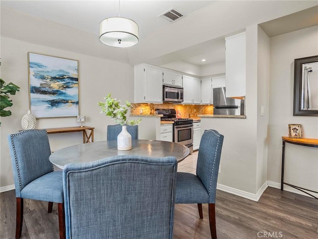 dining room featuring recessed lighting, visible vents, baseboards, and wood finished floors