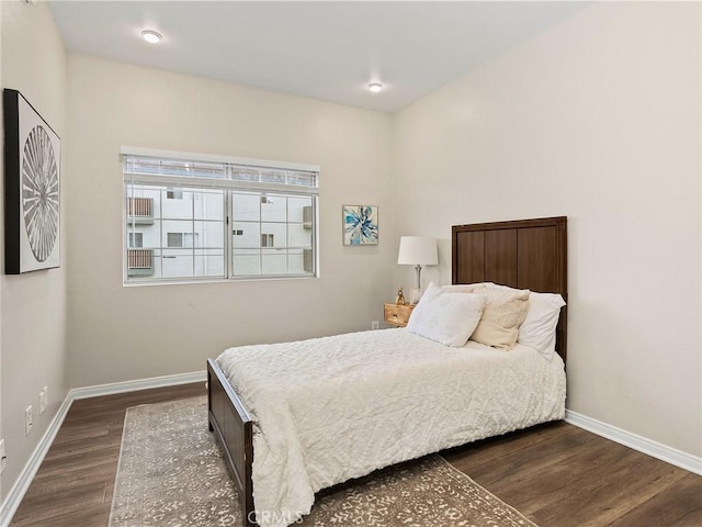 bedroom with dark wood-style floors and baseboards