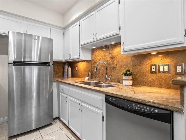 kitchen featuring a sink, backsplash, appliances with stainless steel finishes, white cabinets, and light tile patterned floors