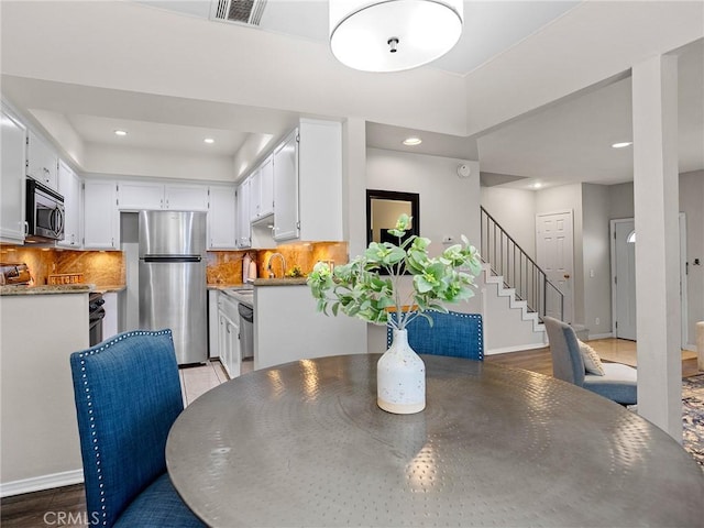 dining room featuring stairway, recessed lighting, baseboards, and visible vents