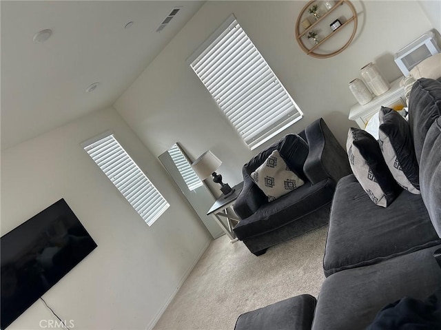 living area with visible vents, carpet, and vaulted ceiling