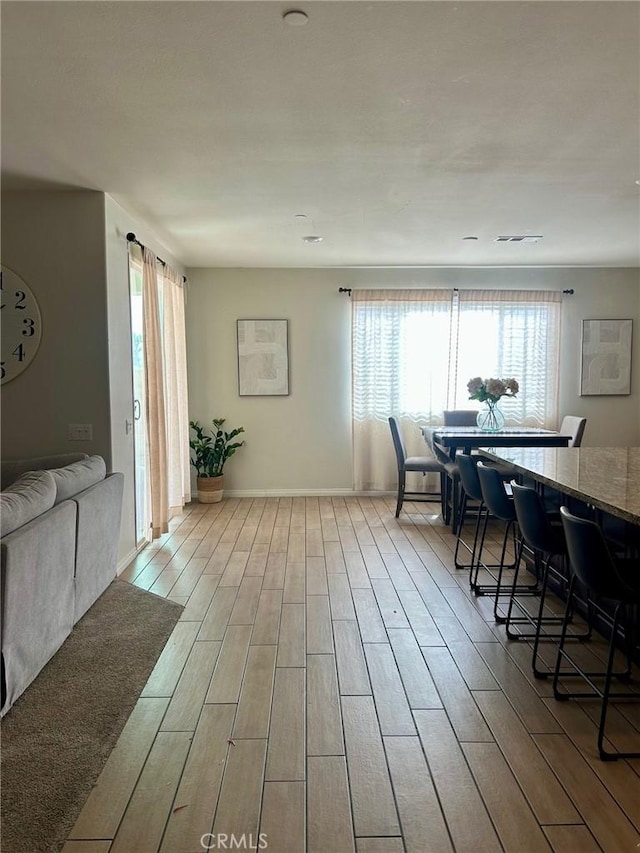 living room featuring visible vents, baseboards, and wood finish floors