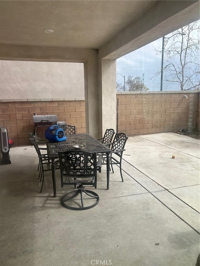 view of patio with outdoor dining area and fence