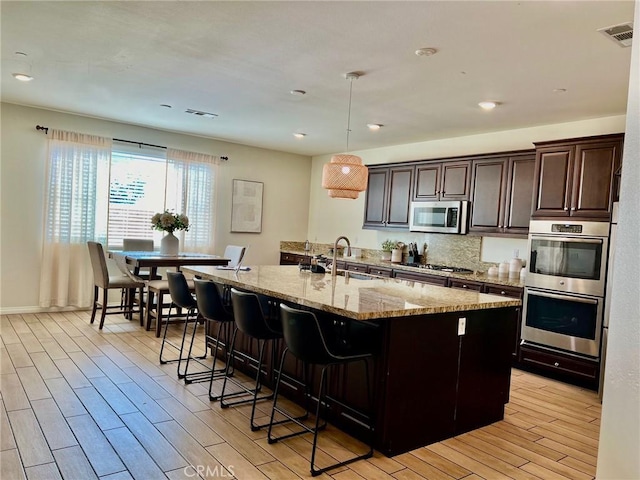 3204 E Denali Dr, Ontario, CA 91762 - kitchen with visible vents, a sink, appliances with stainless steel finishes, light wood finished floors, and light stone countertops