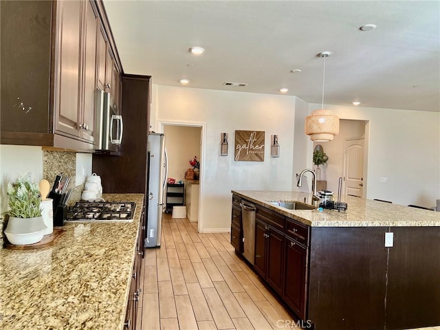 3204 E Denali Dr, Ontario, CA 91762 - kitchen with visible vents, a center island with sink, a sink, appliances with stainless steel finishes, and decorative backsplash