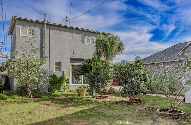 rear view of property featuring stucco siding