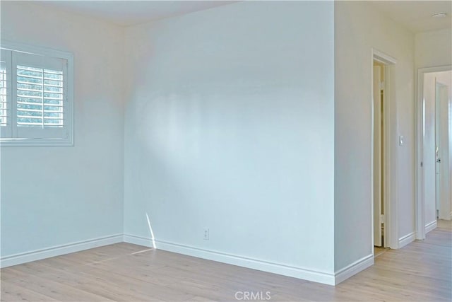 spare room with light wood finished floors and baseboards