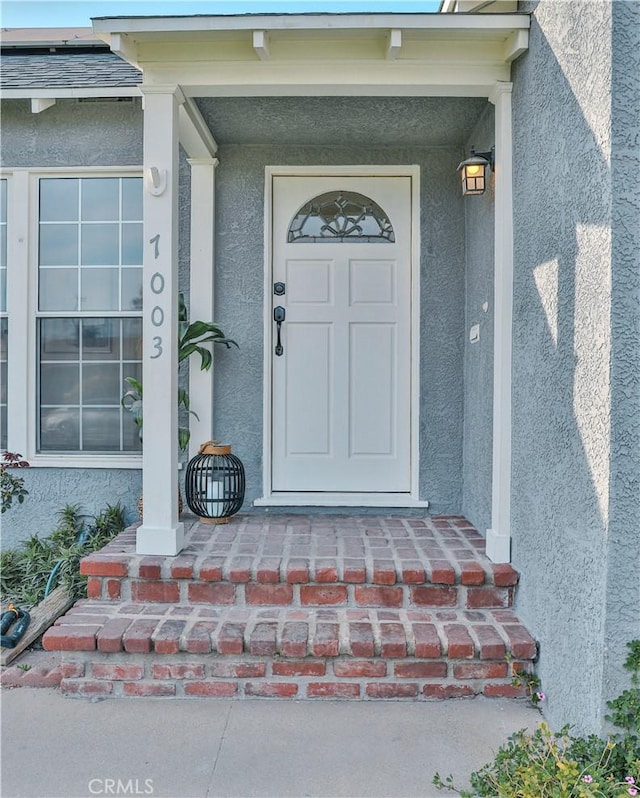 view of exterior entry with stucco siding