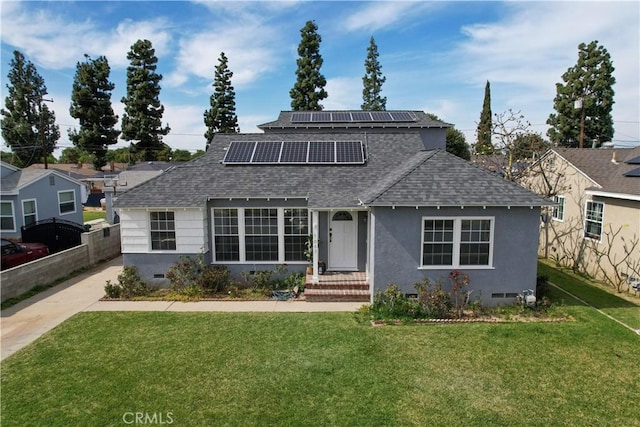 traditional-style home with a shingled roof, a front yard, solar panels, and crawl space