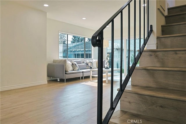 stairway with recessed lighting, wood finished floors, and baseboards