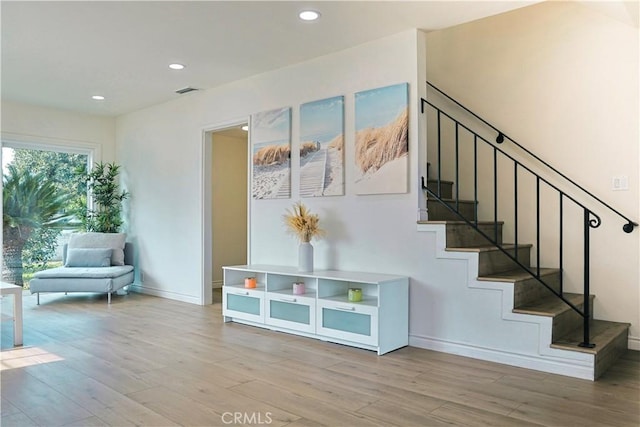 stairs with recessed lighting, baseboards, and wood finished floors