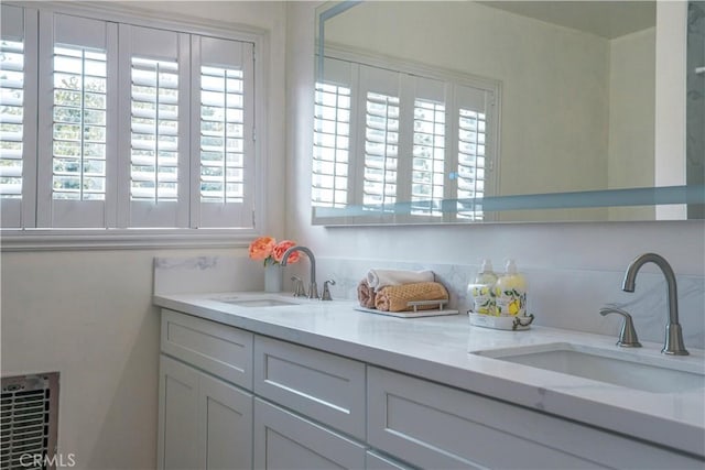 full bathroom with double vanity, a wealth of natural light, and a sink