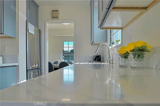 kitchen featuring light countertops, freestanding refrigerator, and a sink