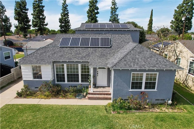 traditional-style house with a front lawn, roof mounted solar panels, roof with shingles, and crawl space