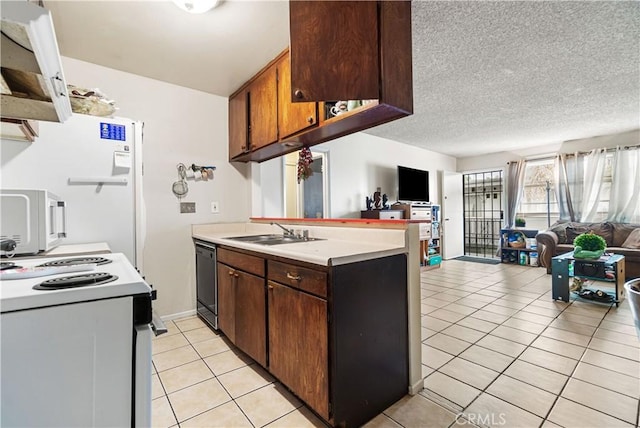 kitchen with a sink, white appliances, open floor plan, and light countertops