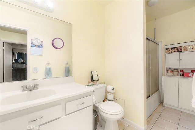 bathroom featuring tile patterned flooring, toilet, vanity, and bath / shower combo with glass door