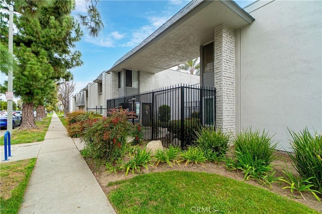 view of property exterior with stucco siding and fence