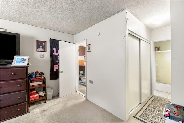 carpeted bedroom with a closet and a textured ceiling