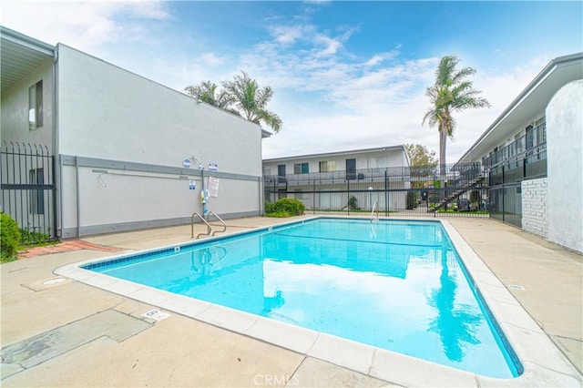 pool with a patio area and fence