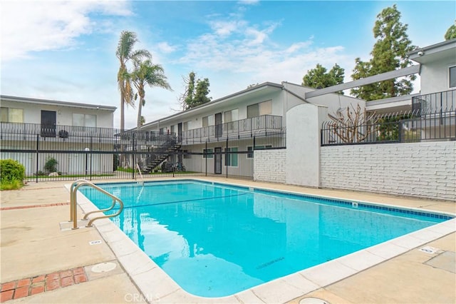 community pool featuring a patio and fence