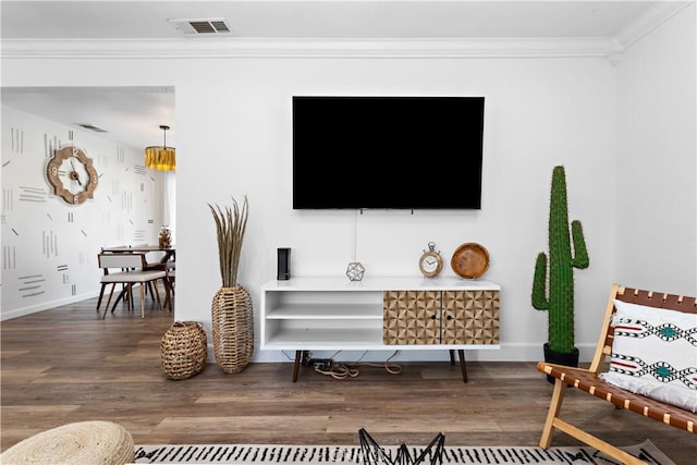 interior space featuring visible vents, wood finished floors, baseboards, and ornamental molding