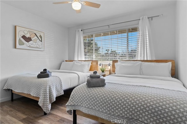 bedroom featuring a ceiling fan, wood finished floors, and baseboards