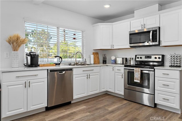 56838 Bonanza Dr, Yucca Valley, CA 92284 - kitchen featuring appliances with stainless steel finishes, a sink, light wood-style floors, white cabinetry, and recessed lighting