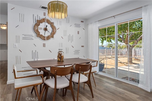 dining area with visible vents and wood finished floors