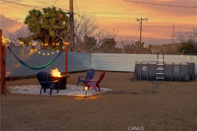 view of play area with fence and an outdoor fire pit