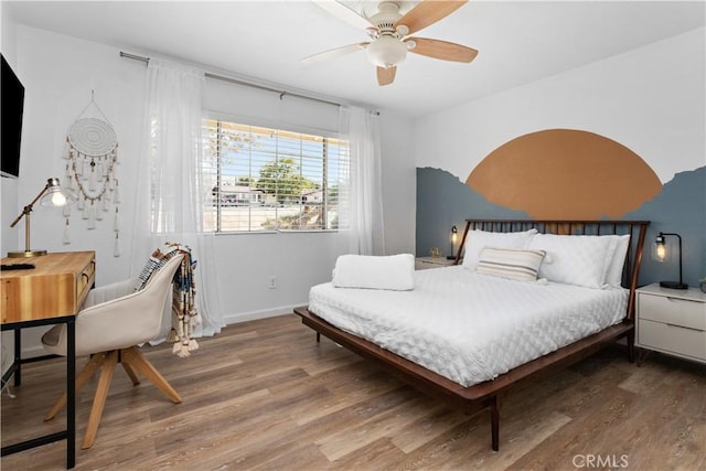 bedroom featuring a ceiling fan, baseboards, and wood finished floors