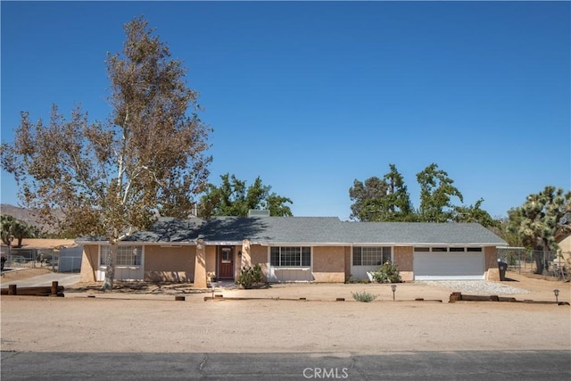 single story home featuring a garage and fence