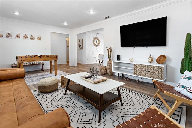 living room with visible vents, recessed lighting, crown molding, and wood finished floors