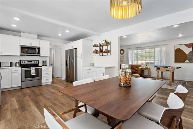 dining room with recessed lighting, beamed ceiling, and wood finished floors