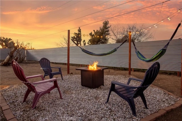 patio terrace at dusk featuring a fire pit