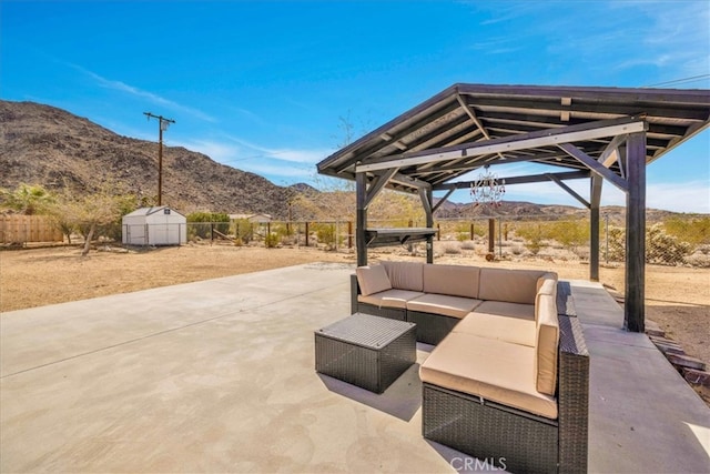 7068 Eucalyptus Ave Unit 29, Palms, CA 92277 - view of patio featuring a mountain view, an outdoor living space, a shed, an outbuilding, and a fenced backyard