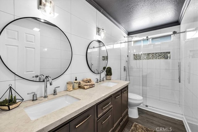 7068 Eucalyptus Ave Unit 29, Palms, CA 92277 - full bathroom featuring double vanity, a shower stall, a textured ceiling, wood finished floors, and tile walls