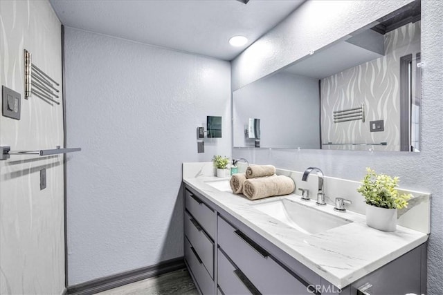7068 Eucalyptus Ave Unit 29, Palms, CA 92277 - bathroom featuring a textured wall, double vanity, and wood finished floors
