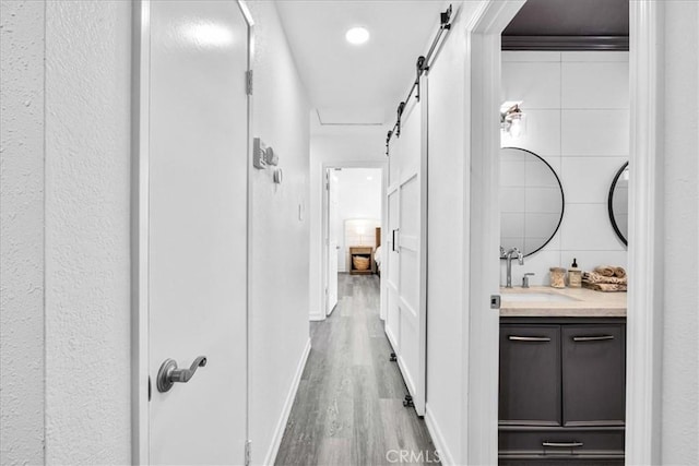 7068 Eucalyptus Ave Unit 29, Palms, CA 92277 - corridor featuring a barn door and wood finished floors