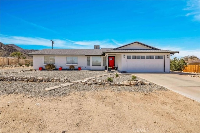 ranch-style house with stucco siding, an attached garage, concrete driveway, and fence